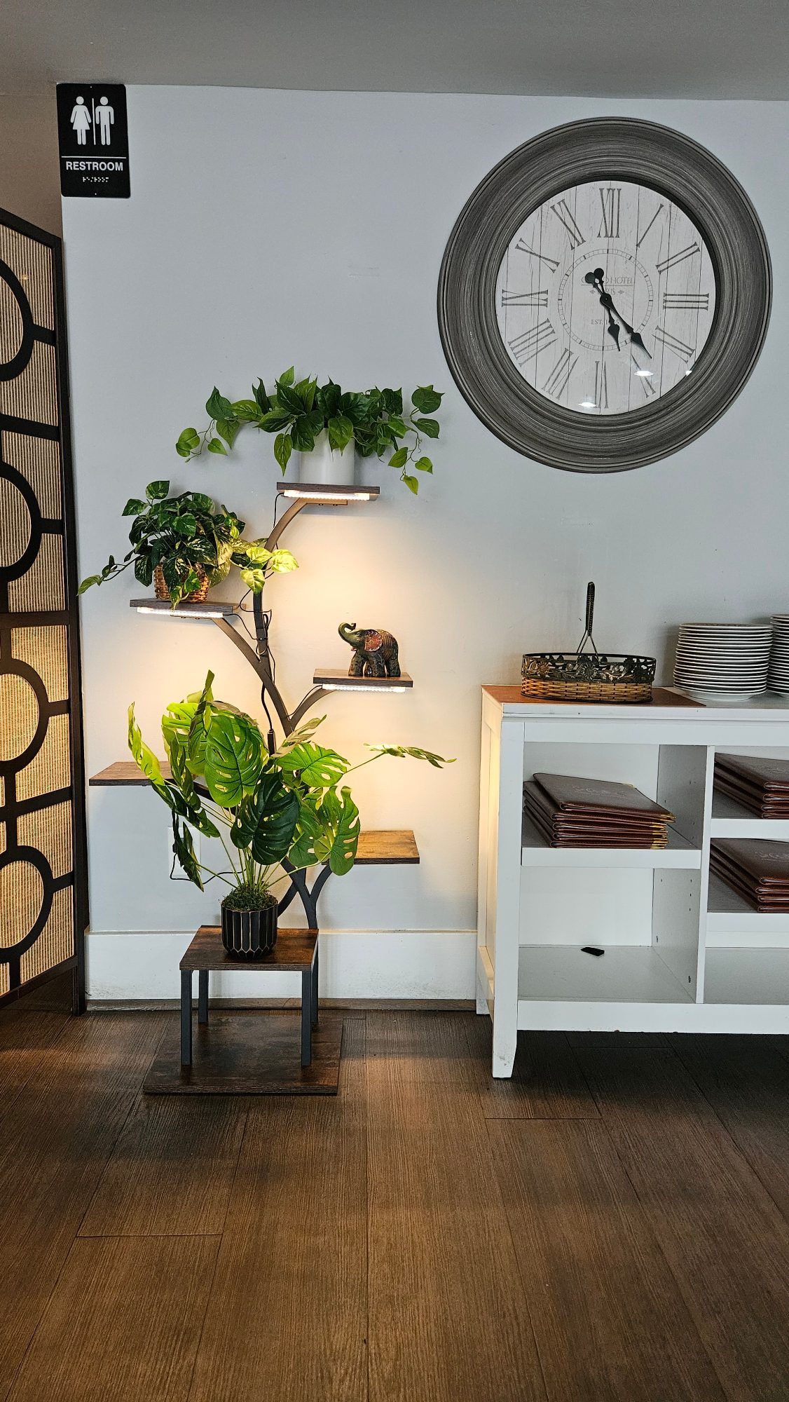 Plant shelf, carved elephant and stacked plates in the Punjabi Tadka dining room